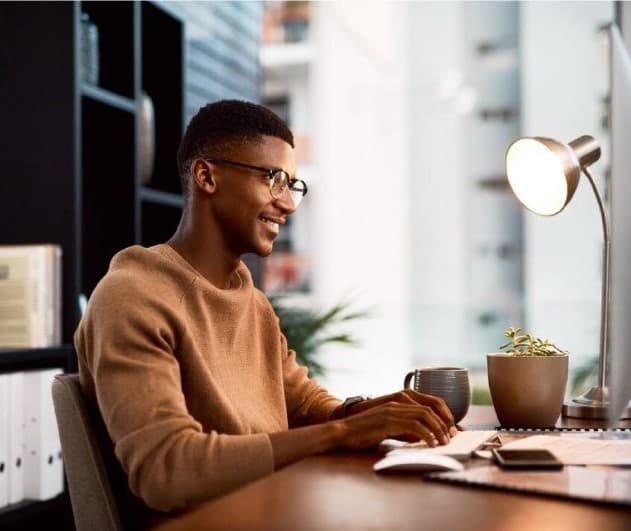 A young black man working on a laptop